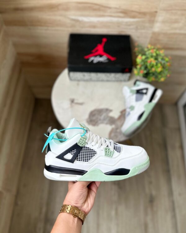 "Jordan Retro 4 Seafoam sneakers in white leather with seafoam green accents, perfect for a stylish and comfortable look."