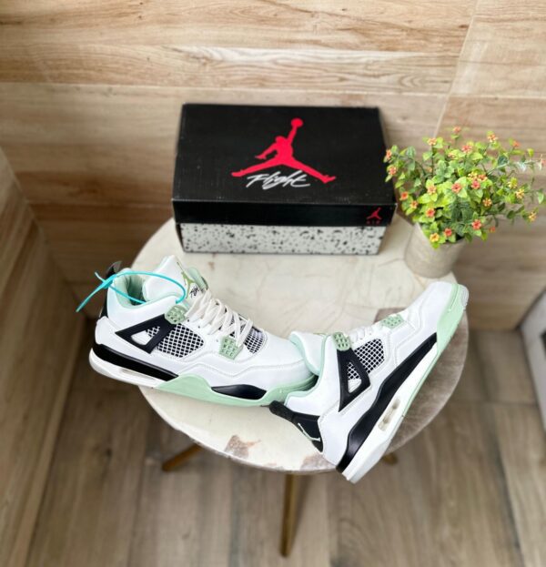 "Jordan Retro 4 Seafoam sneakers in white leather with seafoam green accents, perfect for a stylish and comfortable look."