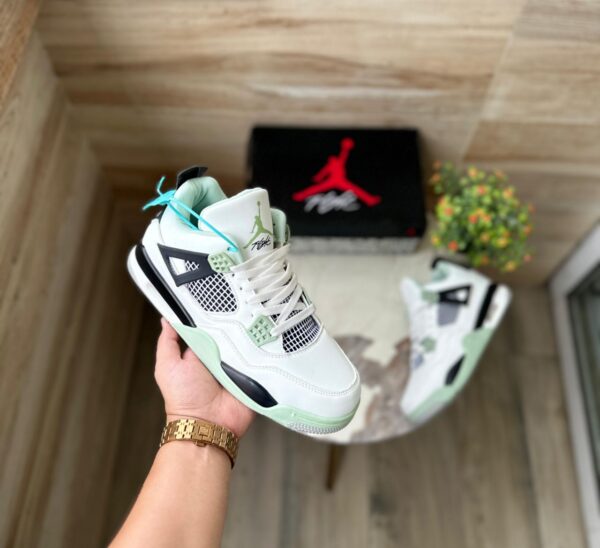 "Jordan Retro 4 Seafoam sneakers in white leather with seafoam green accents, perfect for a stylish and comfortable look."