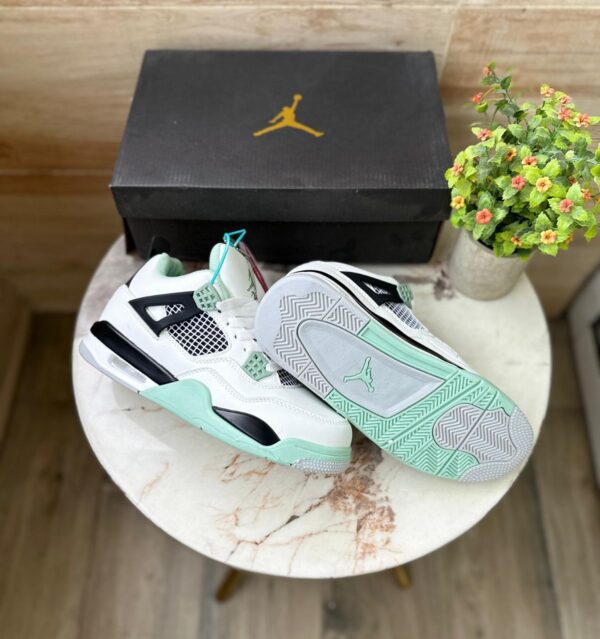 "Jordan Retro 4 Seafoam sneakers in white leather with seafoam green accents, perfect for a stylish and comfortable look."