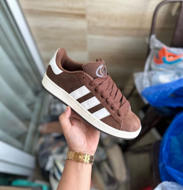 "Adidas Campus Brown sneakers for girls and boys featuring a premium brown suede upper with contrasting white stripes, available in sizes 36 to 45, perfect for casual wear and everyday comfort."