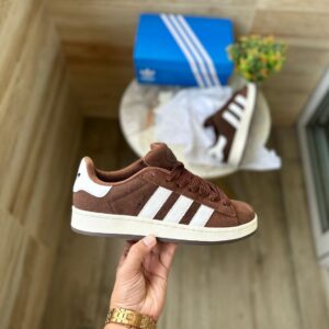 "Adidas Campus Brown sneakers for girls and boys featuring a premium brown suede upper with contrasting white stripes, available in sizes 36 to 45, perfect for casual wear and everyday comfort."