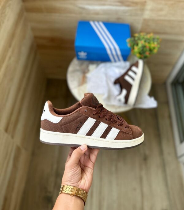 "Adidas Campus Brown sneakers for girls and boys featuring a premium brown suede upper with contrasting white stripes, available in sizes 36 to 45, perfect for casual wear and everyday comfort."