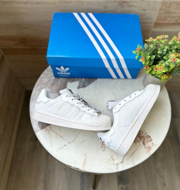 "Adidas Superstar Cappuccino Off White sneaker with a stylish off-white upper and iconic three stripes design.