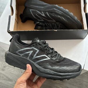 "New Balance Fuel Cell Venym in hand showcasing its vibrant orange and black design."